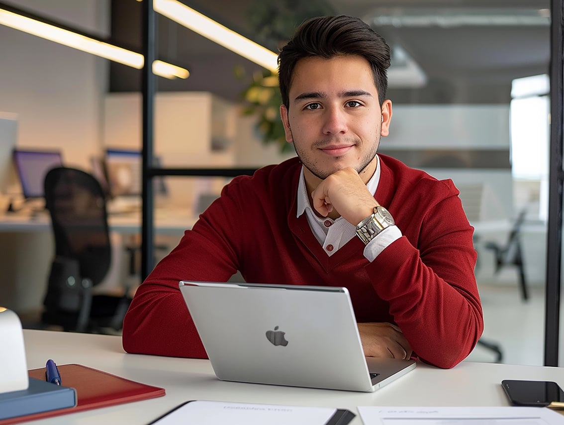 man-sits-desk-with-laptop-pen-him